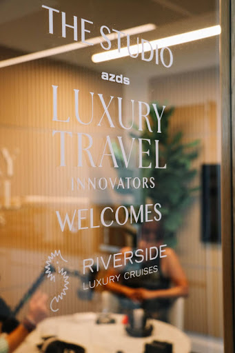 A sign welcoming Riverside Luxury Cruises to the LTI podcast studio.